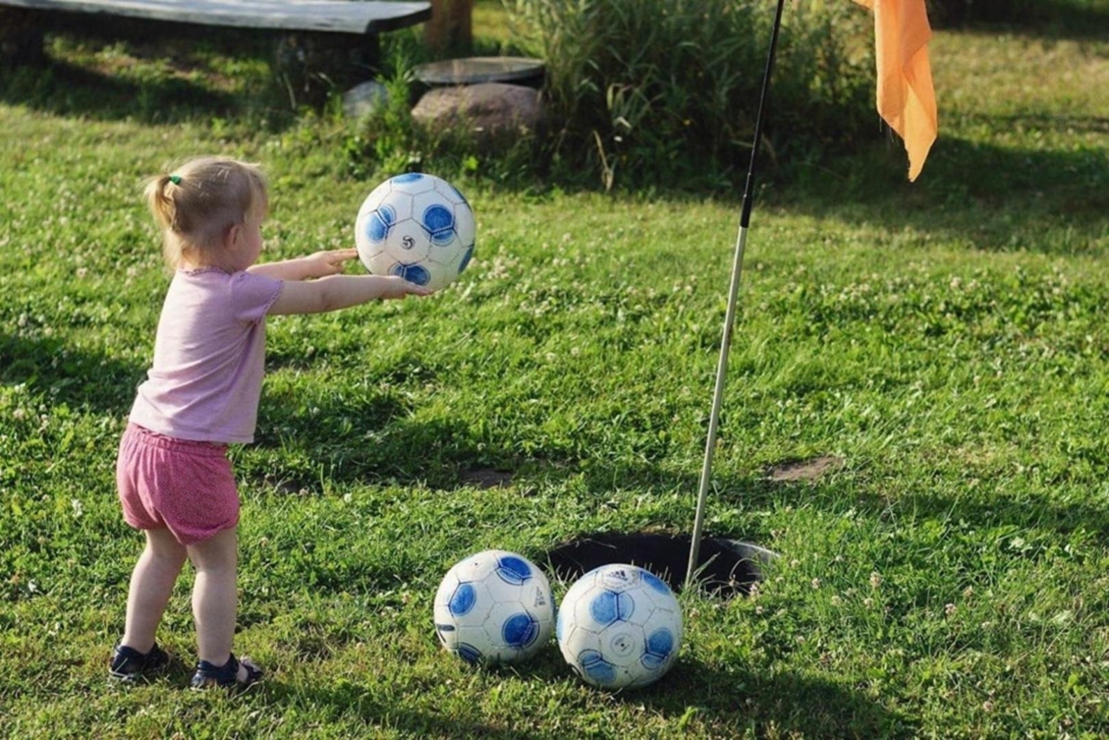 Bērns spēlējas ar futbola bumbu