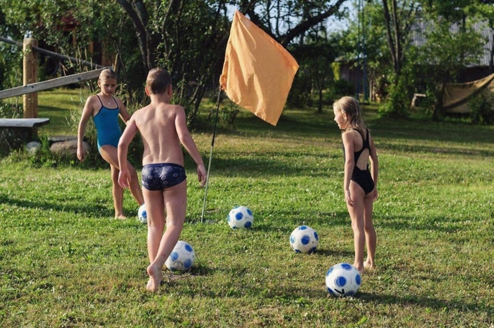 Bērni spēlējas ar futbola bumbām