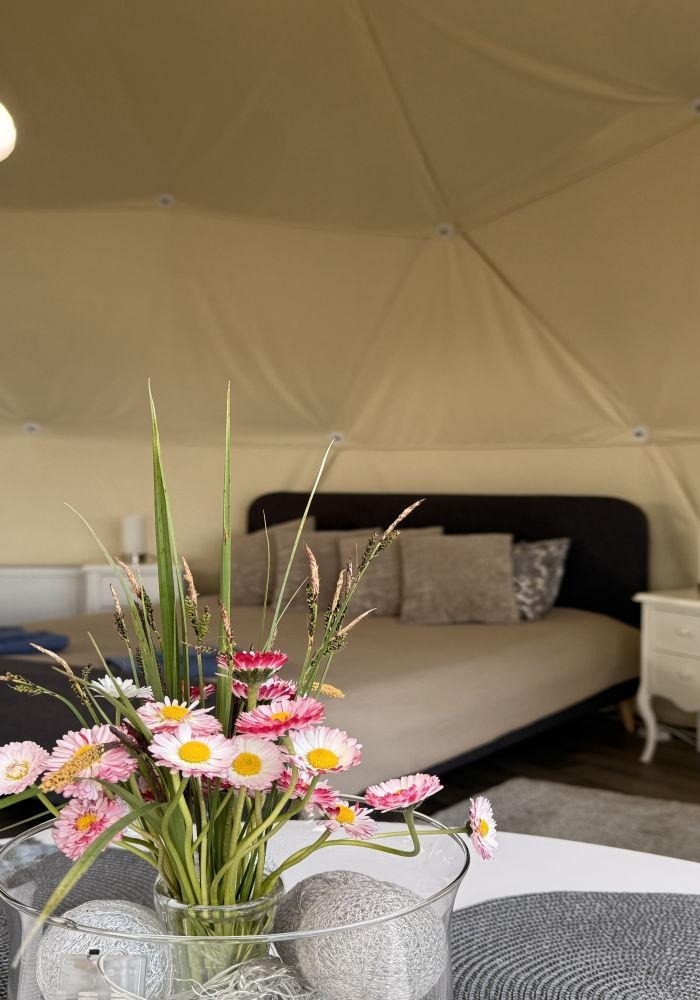 Ziedi un gulta glampinga teltī