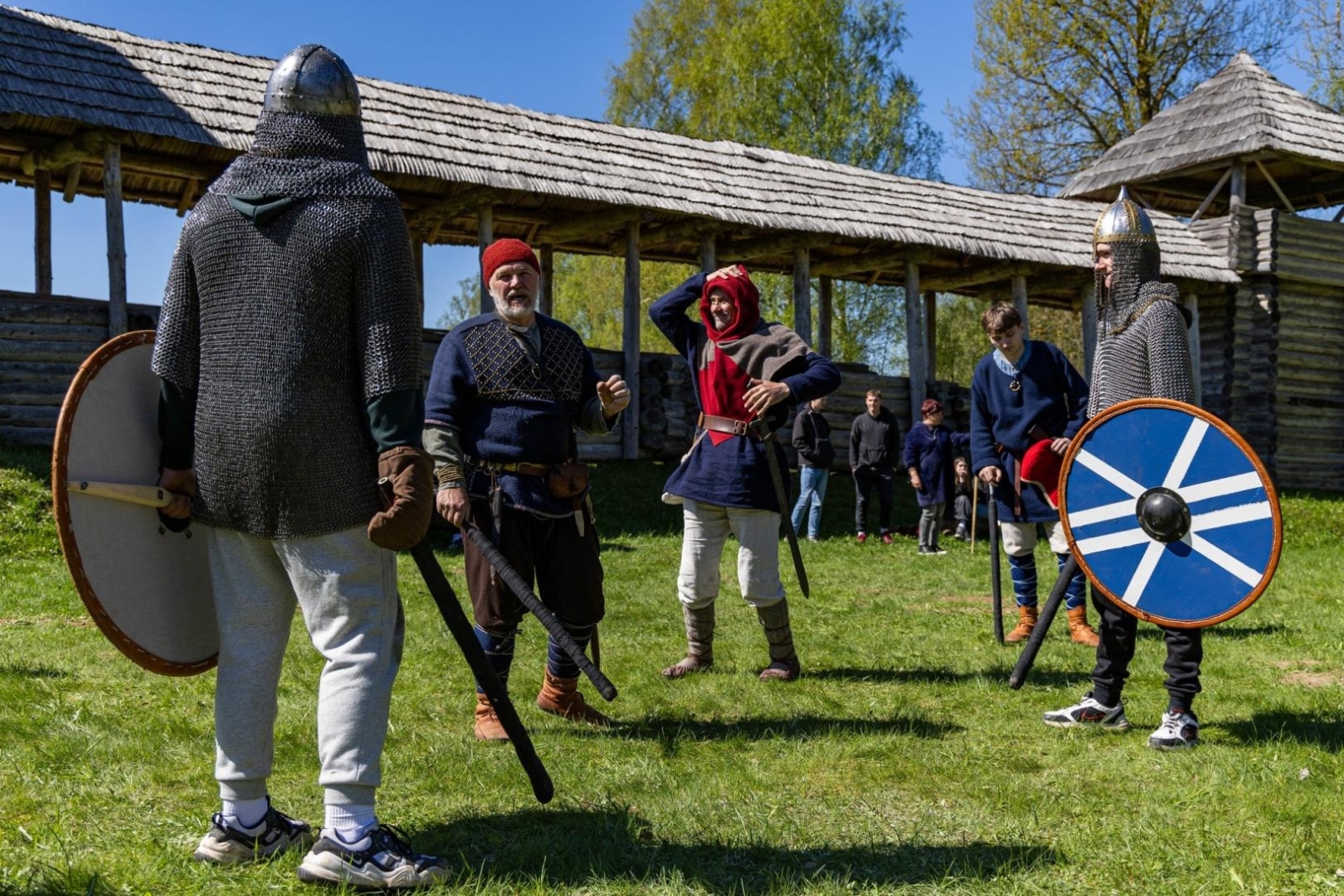 Cilvēki viduslaiku tērpos ar vairogiem