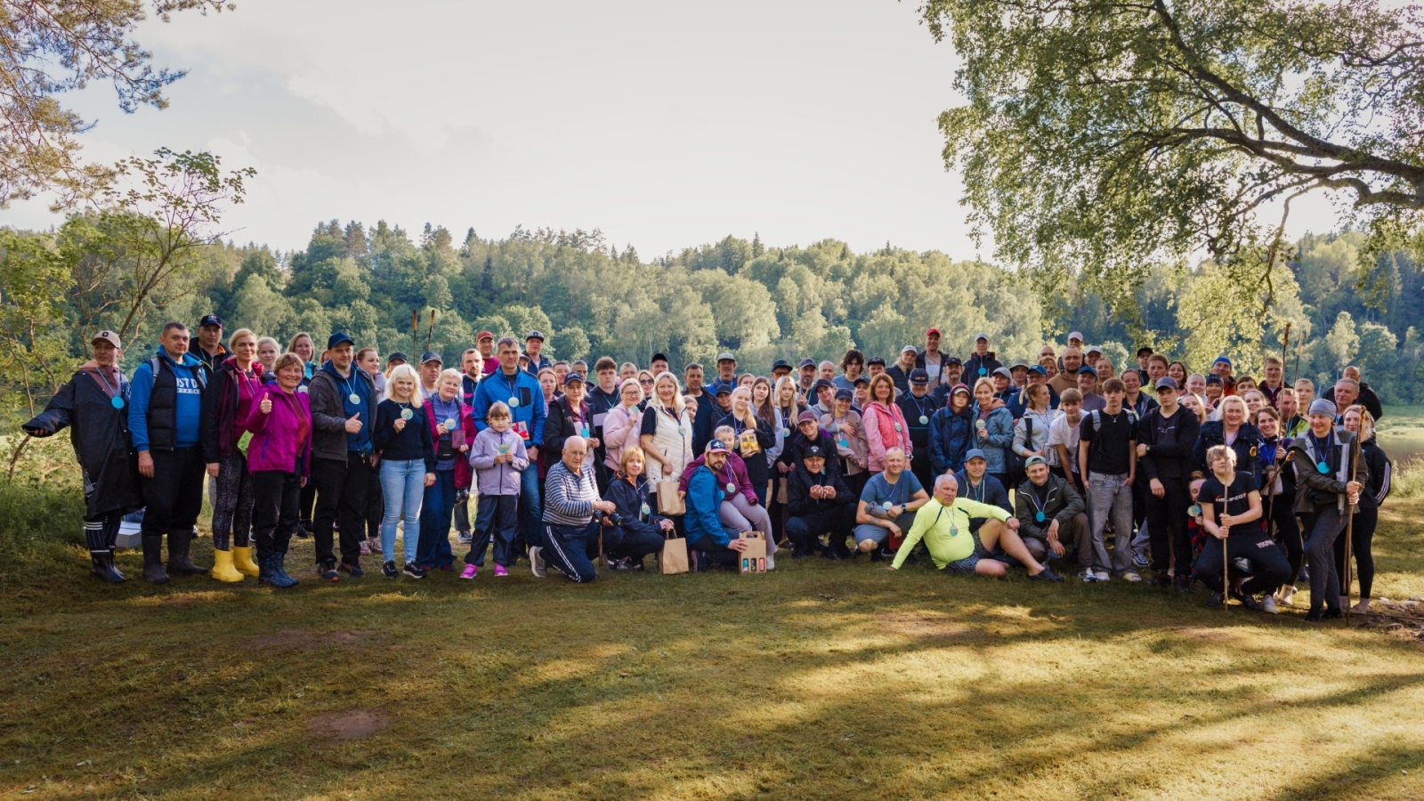 Visi pasākuma dalībnieki kopīgā noslēguma fotogrāfijā pie upes