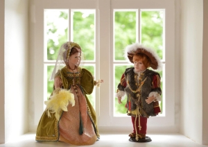 Divas porcelāna lelles pie loga
