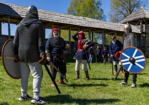 Cilvēki viduslaiku tērpos ar vairogiem